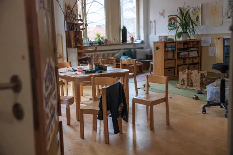 Illustrationsbild: Ein benutzter Gruppenraum mit kleinen Holztischen und Spielsachen